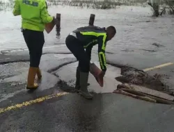 Personil Polres Pelalawan Berjibaku Bersama Masyarakat Timbun Jalan Rusak Akibat Banjir